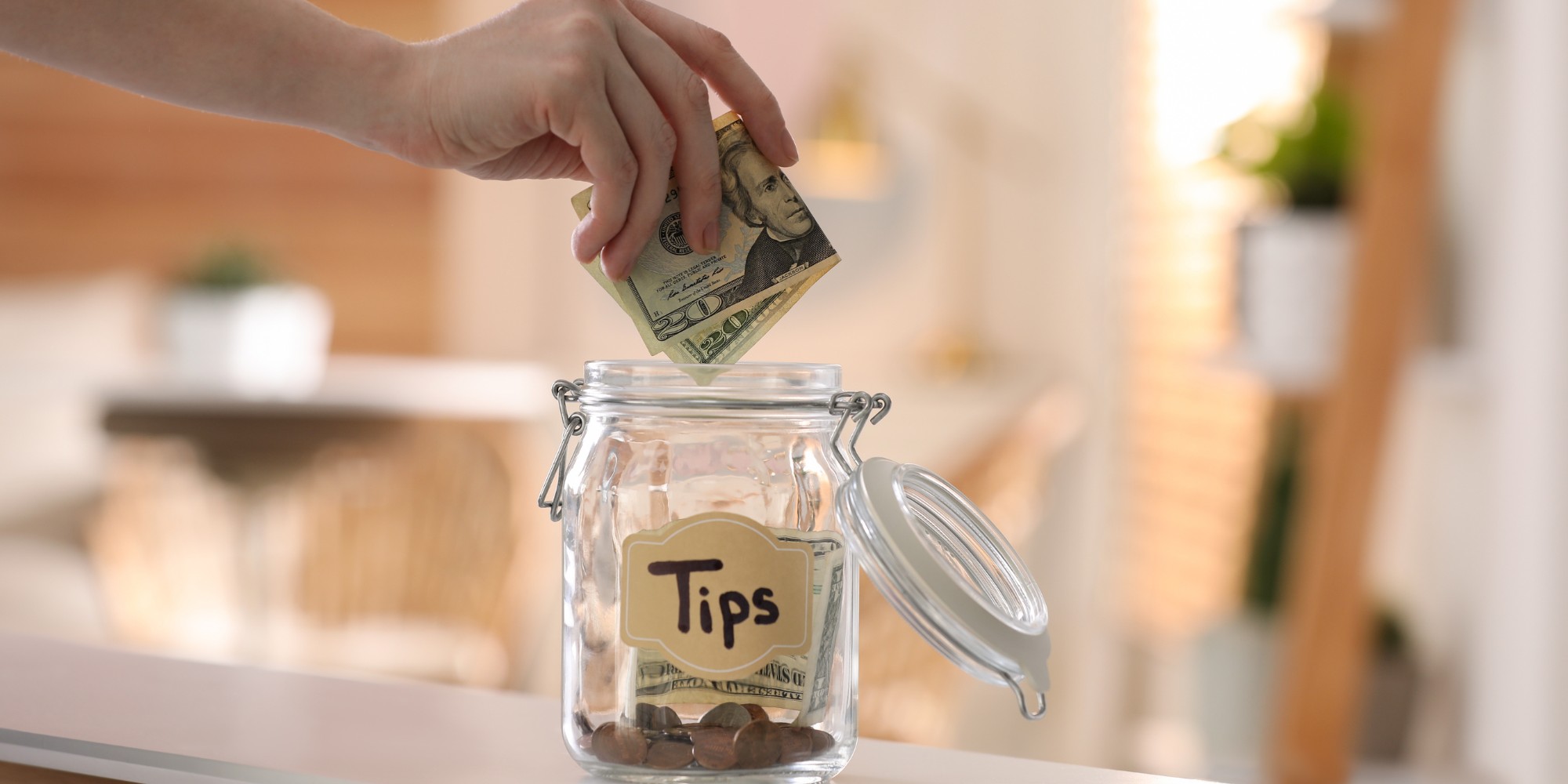 Putting cash in a money-filled tips jar from the top ATM service provider in Hawaii.